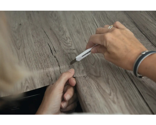 Een vinyl vloerpaneel snijden met een stanleymes.