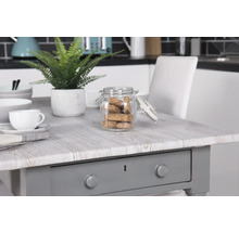 Decoratieve opstelling met tafel, servies en voorraadpot in een keuken.