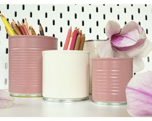 Decoratieve pennenbakjes gemaakt van blikken met kleurpotloden en een magnolia bloem