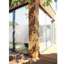Buitenkant van een modern huis met houten bekleding en grote ramen met privacyfolie.