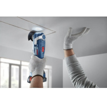 Persoon snijdt met een multifunctioneel gereedschap een vierkante opening in een plafond.