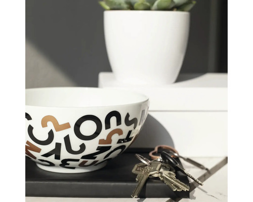 Decoratieve kom met letterpatroon, kamerplant in witte pot en sleutelbos op een plank.