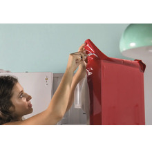 Vrouw beplakt een koelkast met een rode folie