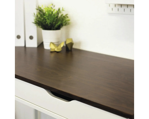 Detailopname van een bureau met lade, decoratie en kantoorplant