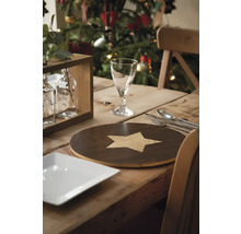 Feestelijk gedekte houten tafel met servies, bestek en decoratie voor een kerstboom.