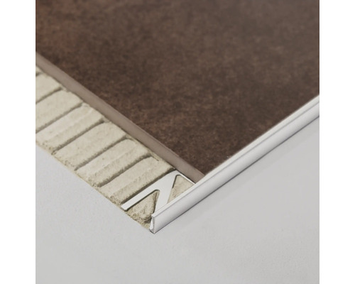 Detailopname van een metalen tegelstrip tussen een tegel en de ondergrond