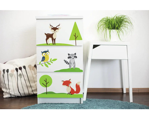 Ladekast met bosdiermotieven in de kinderkamer naast een bijzettafel en kussen