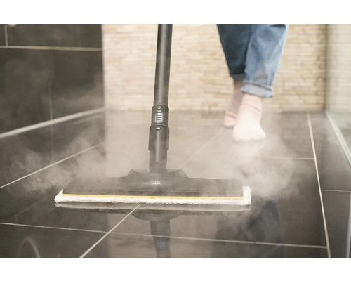 Stoomreiniger in gebruik op tegelvloer in badkamer