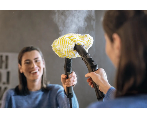 Een vrouw gebruikt een stoomreiniger met gele hoes voor reiniging