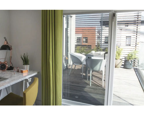 Lichte kamer met bureau, stoel en gordijn, uitzicht op een terras met tafel en stoelen