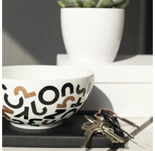 Decoratieve schaal met letterpatroon, potplant en sleutels op een tafel