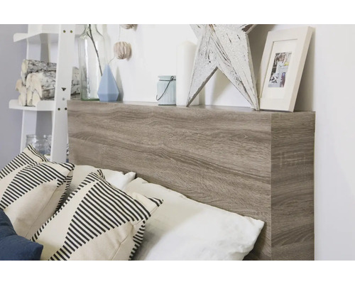 Bed met hoofdeinde in houtlook en opbergplank met decoratieve items en kussens