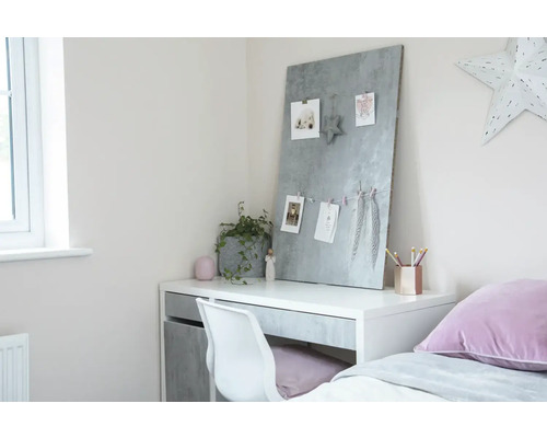 Bureau met memobord, stoel en decoratie in een heldere kamer.