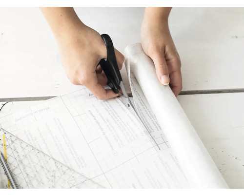 Het op maat snijden van de folie met een schaar.