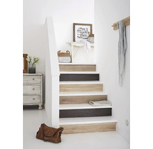 Trap met houten treden en decoratie in een lichte hal.