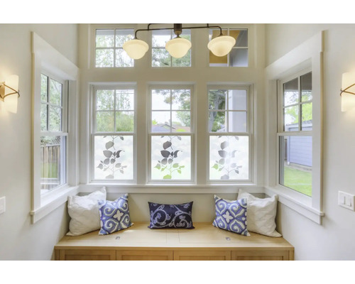 Zithoek met ramen, versierd met raamfolie met plantmotieven en sierkussens