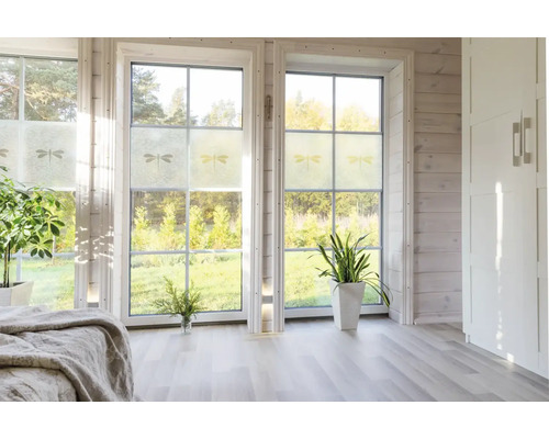 Lichte kamer met raamfolie met libellemotief voor raamdecoratie.