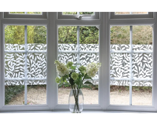 Raam met privacyfolie met plantenpatroon en bloemboeket in vaas