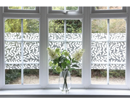 Decoratieve folie met bladerdesign op raam met bloemenvaas