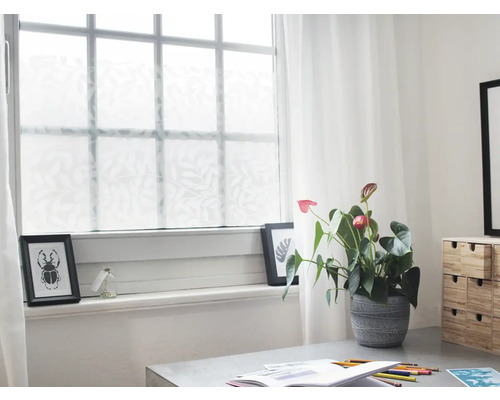 Scene met raamfolie met bladmotief, anthurium en bureau.