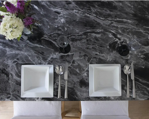 Gedekte eettafel met marmeren blad, borden, bestek, glazen en bloemenvaas