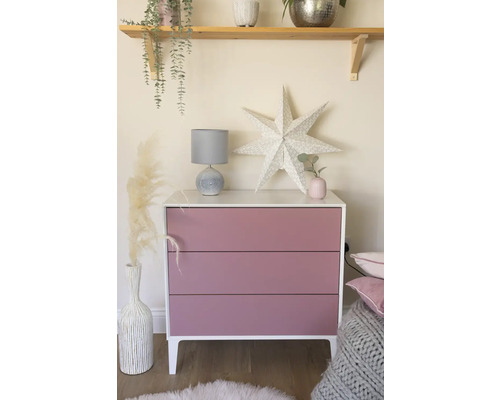 Commode met drie laden, lamp en decoratie in een lichte kamer