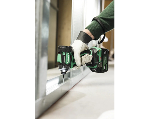 Een persoon schroeft met een HiKoki accuslagschroevendraaier een schroef in een metalen profiel.