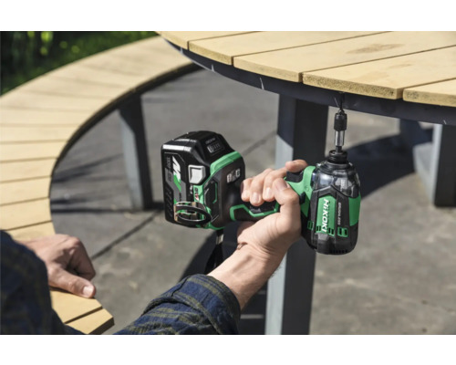 Iemand gebruikt een HiKoki accuslagschroevendraaier aan een tuintafel.