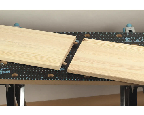 Houten plank met pluggen voor verbinding op een werkbank