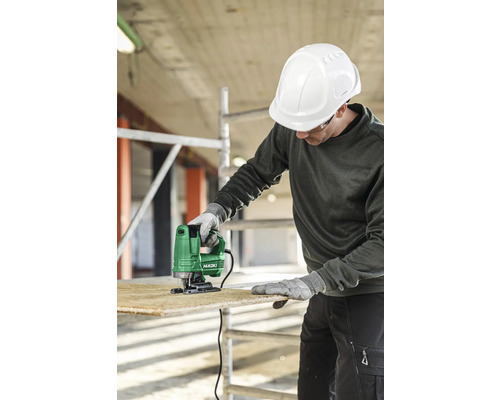 Een man met een veiligheidshelm zaagt hout met een decoupeerzaag van het merk HiKOKI.