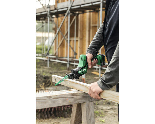 Iemand zaagt een houten plank door met een Hikoki accusloopzaag.