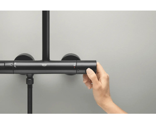 Grohe Logo op een douchearmatuur waar een hand de temperatuur aanpast