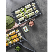 Twee schalen met sushi, gember, zeewier en een groene theepot op een grijze achtergrond.