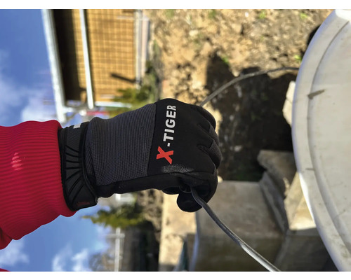 Een hand met X-Tiger handschoen houdt een kabel vast.