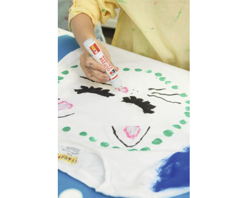 Persoon versiert een T-shirt met een glitterstift.