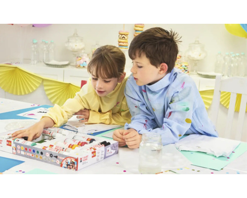 Twee kinderen beschilderen textiel met textielstiften aan een tafel.