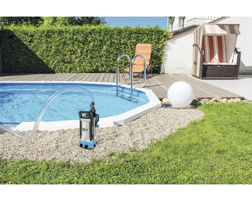 Dompelpomp bij zwembad met tuinmeubelen op de achtergrond