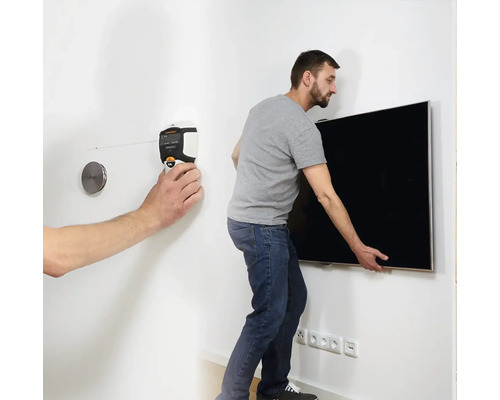 Man monteert een televisie aan de muur met behulp van een waterpas.