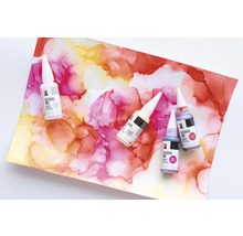 Meerdere flessen alcoholinkt op een achtergrond met abstracte kleurpatronen.