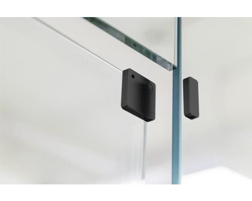 Detailopname van een douchecabine met zwarte fittingen