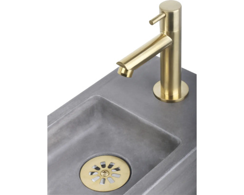 Afbeelding van een wastafel met goudkleurige kraan en afvoer
