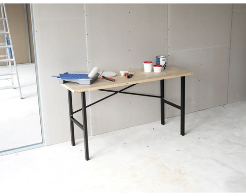 Scène met behangtafel, verf, verfroller en gereedschap in een kamer.
