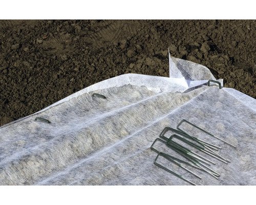 Tuinvlies met bevestigingspennen op de grond