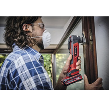 Man werkt met een Einhell multitool aan een raamkozijn