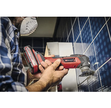 Een man werkt met een Einhell multitool aan tegels.