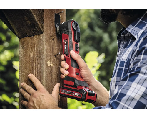Een man gebruikt een Einhell draadloos multifunctioneel gereedschap op een houten balk