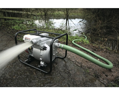 Waterpomp met slang in gebruik voor het leegpompen van een overstroomd gebied