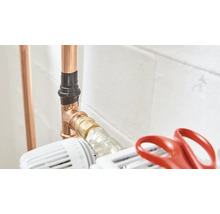 Koperen pijpsysteem met pijpisolatie en radiatorkraan.