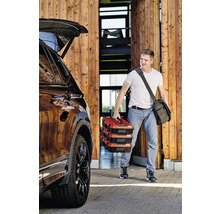 Man draagt drie gereedschapskisten naar de auto