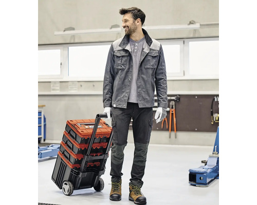 Ambachtsman met gereedschapskoffer trolley in een werkplaats